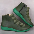 Par de ankle boots de couro verde com sola azul-petróleo brilhante e tiras elásticas.