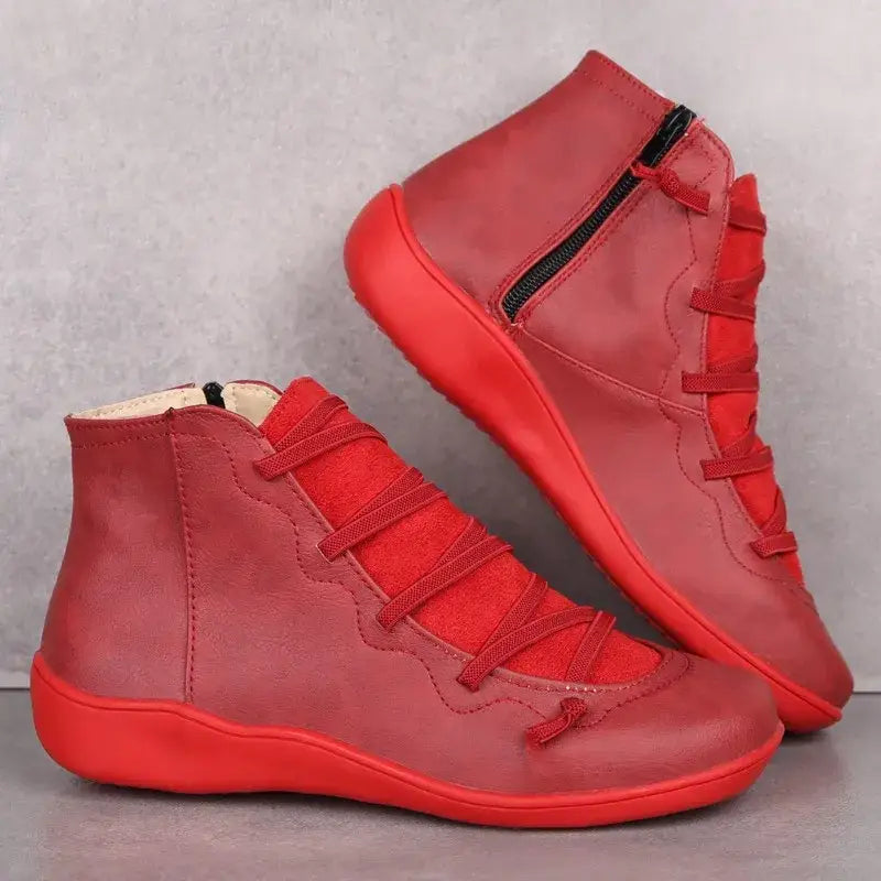 Par de botas de couro vermelho brilhante com cadarço elástico e sola plana.