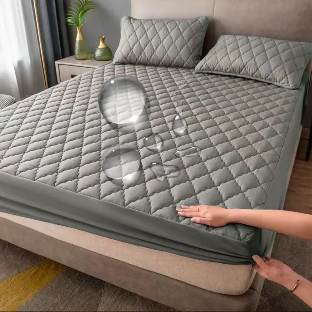 Capa de colchão ou colcha cinza acolchoada sendo colocada em uma cama.