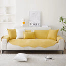 Sofá amarelo e branco com almofadas decorativas.