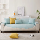 Sofá bege com almofadas azuis claras e uma almofada de destaque amarela.