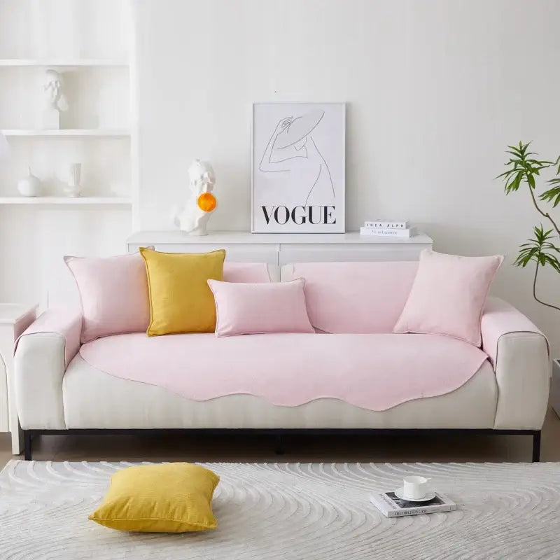 Sofá rosa e branco com almofadas amarelas e rosa.