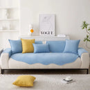 Sofá azul-claro e branco com almofadas amarelas e azuis.