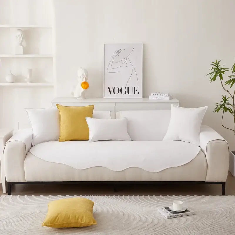 Sofá branco com almofadas amarelas e brancas.