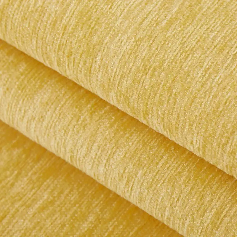 Camadas dobradas de tecido ou material texturizado amarelo-claro.