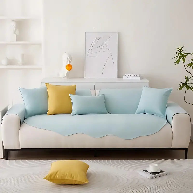 Sofá azul-claro e branco com almofadas amarelas e azuis.