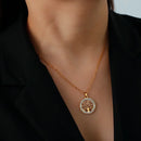 Colar com pingente de ouro com desenho circular da árvore da vida.