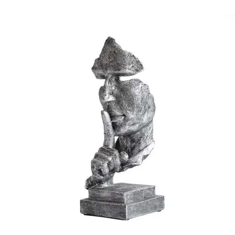 Escultura de uma figura contemplativa com a mão no queixo, sentada em uma pose pensativa.