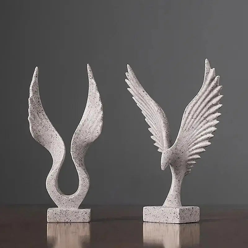 Duas esculturas abstratas em forma de asa feitas de pedra ou concreto.