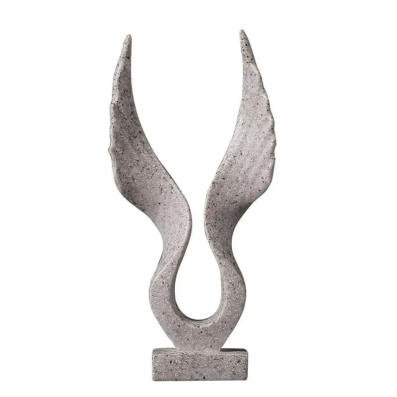 Escultura abstrata de pedra que lembra asas ou chamas curvadas e voltadas para cima.