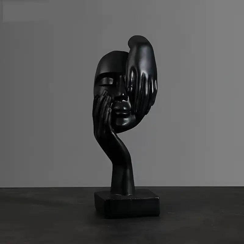 Busto escultural preto com um rosto parcialmente obscurecido por uma mão.
