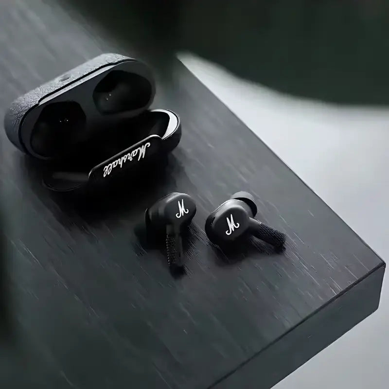 Par de fones de ouvido sem fio pretos com o estojo de carregamento.