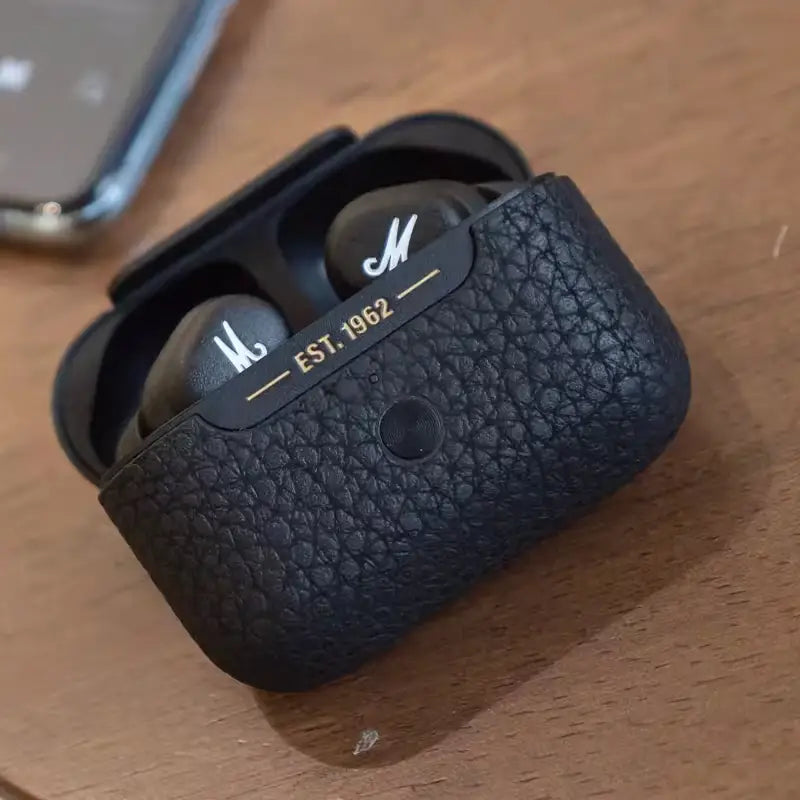Estojo de couro preto para fones de ouvido sem fio com a marca ’M’.