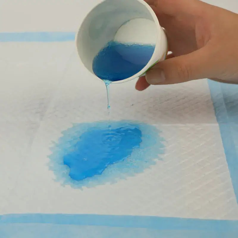 Copo de líquido azul sendo derramado sobre papel.