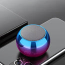 Alto-falante Bluetooth esférico com acabamento metálico gradiente azul e roxo.
