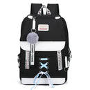 Mochila preta e branca com elementos decorativos, como um charme de pompom e detalhes em cadarço.