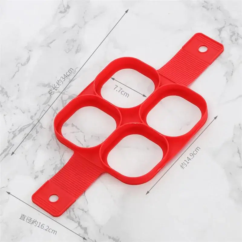 Molde de panqueca de plástico vermelho com quatro aberturas circulares.