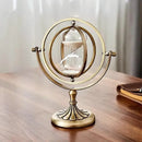 Ampulheta de latão ornamentada com anéis giratórios concêntricos em um suporte decorativo.