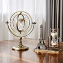 Ampulheta giratória montada em uma estrutura giroscópica de latão em um suporte.