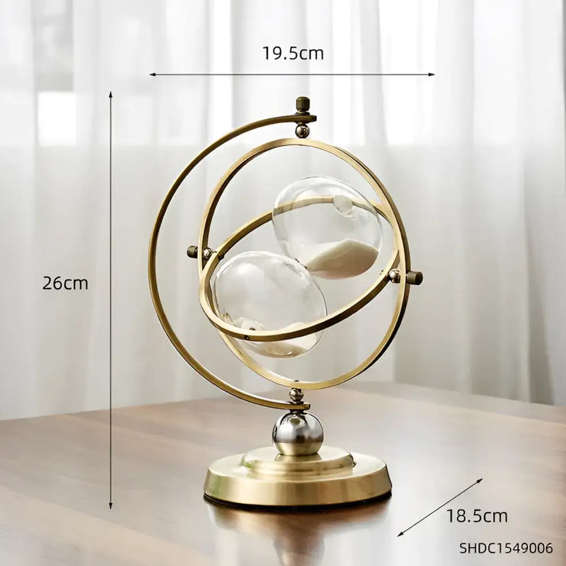 Ampulheta decorativa com anéis de metal dourado que se cruzam em uma base circular.