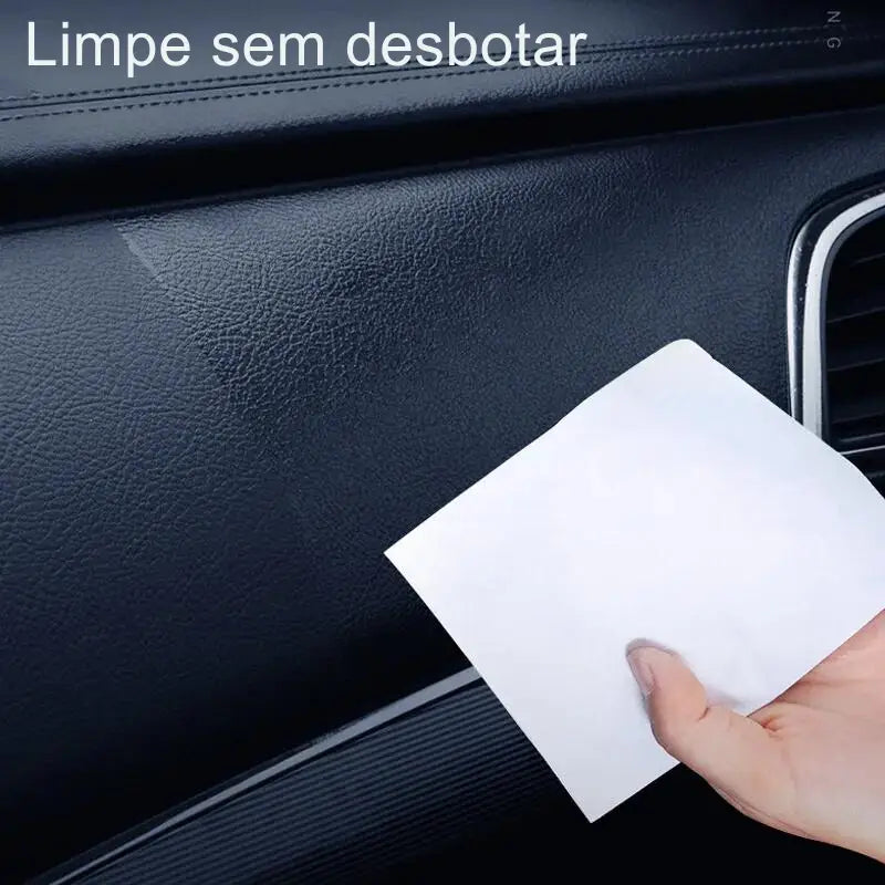 Mão segurando um guardanapo ou lenço de papel branco contra o painel interno de um carro.
