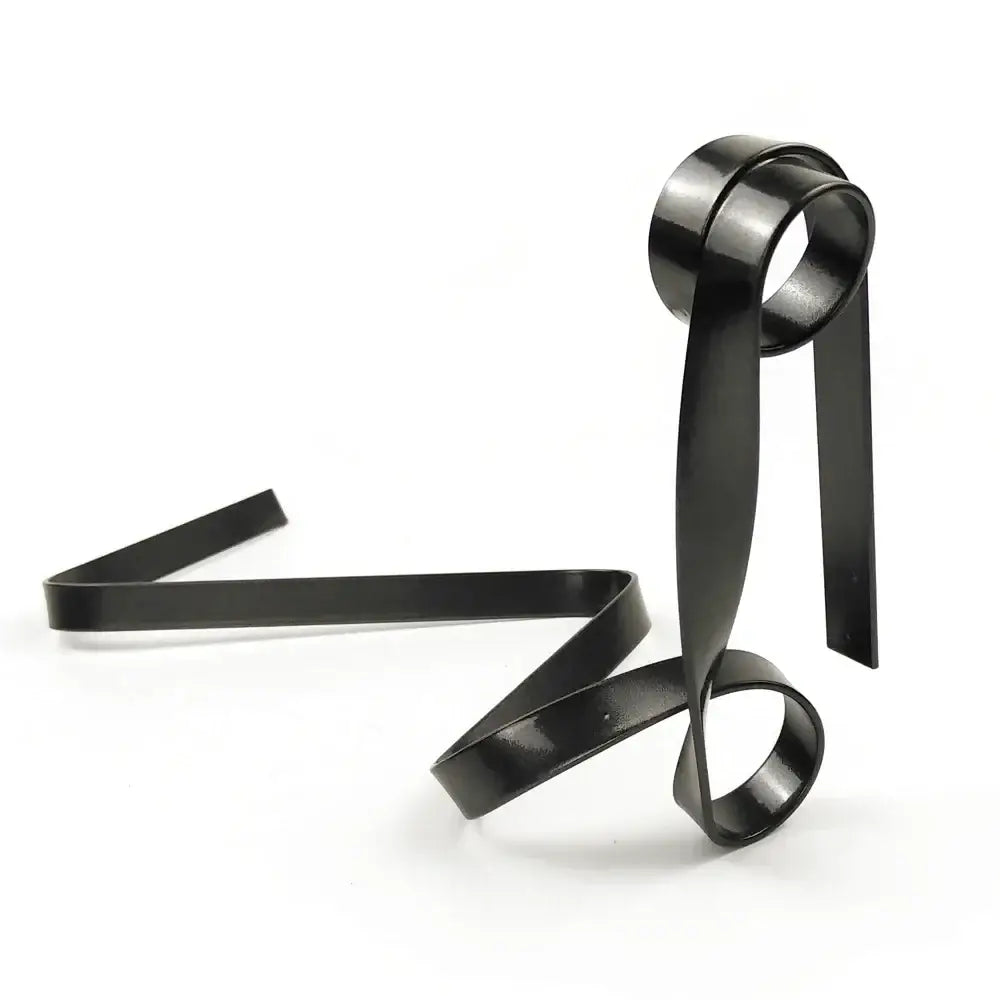 Fita ou faixa de metal preto torcido formando formas esculturais abstratas.