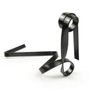 Fita ou faixa de metal preto torcido formando formas esculturais abstratas.