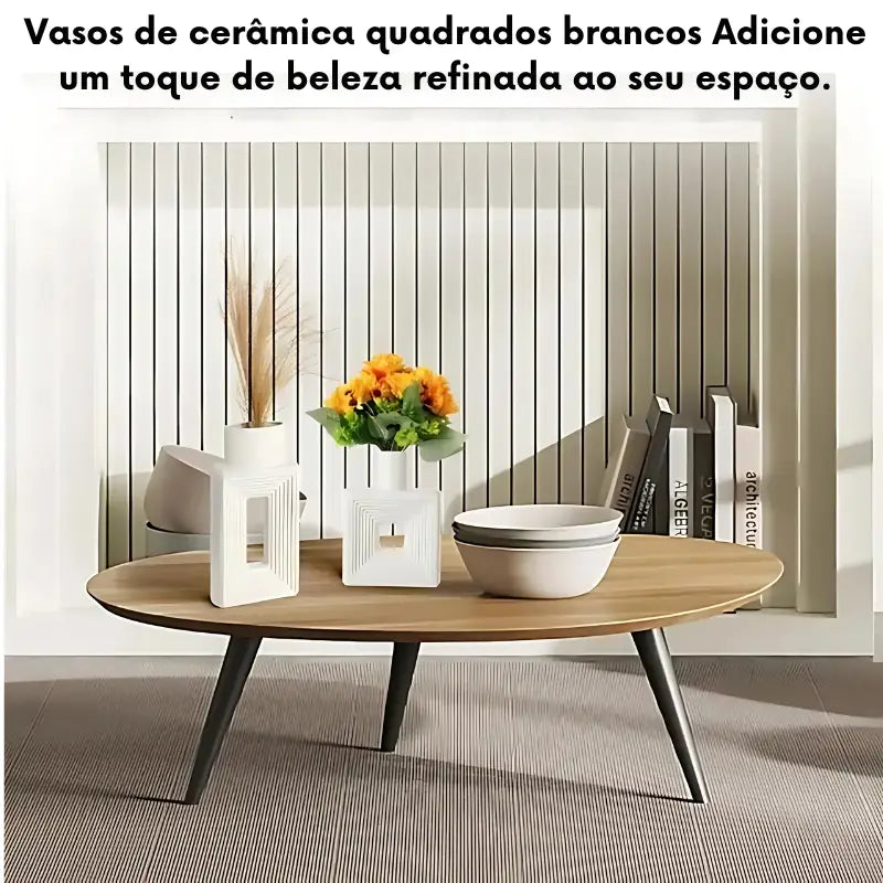 Mesa de centro redonda de madeira com pernas de metal exibindo vasos decorativos e uma tigela.