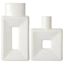 Dois vasos de cerâmica branca com desenhos geométricos em degraus em seus corpos.